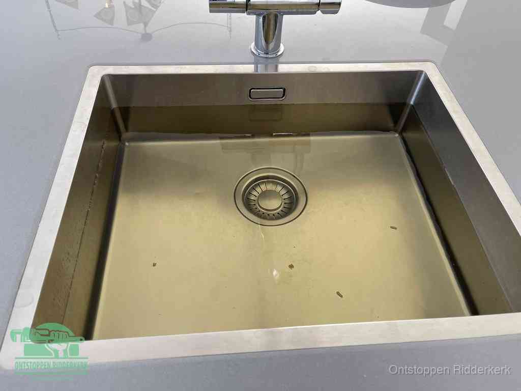 Stilstaand water in een rvs spoelbak dat niet wegloopt, een duidelijk signaal van een gootsteenverstopping in Ridderkerk