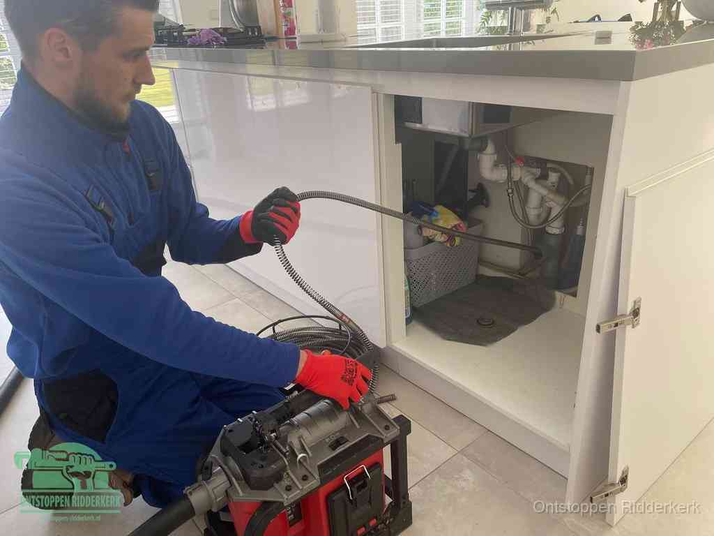 Een monteur reinigt de keukenafvoer grondig met een veermachine om terugkerende gootsteenverstoppingen te voorkomen in Ridderkerk