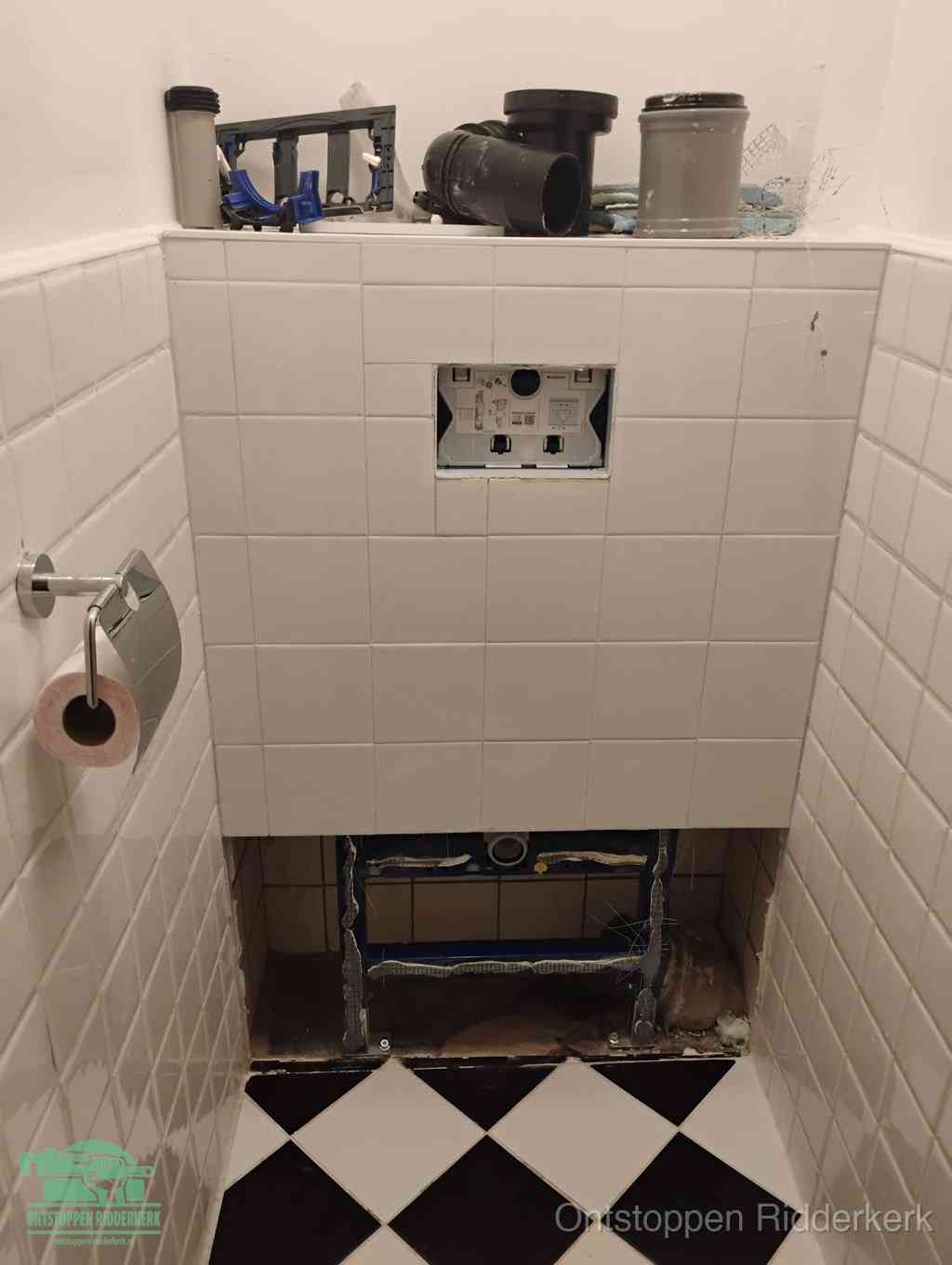 Een toiletruimte waar het hangtoilet en de inbouwreservoir-onderdelen zijn vrijgelegd voor onderhoud, periodiek nazicht voorkomt een wc-verstopping in Ridderkerk